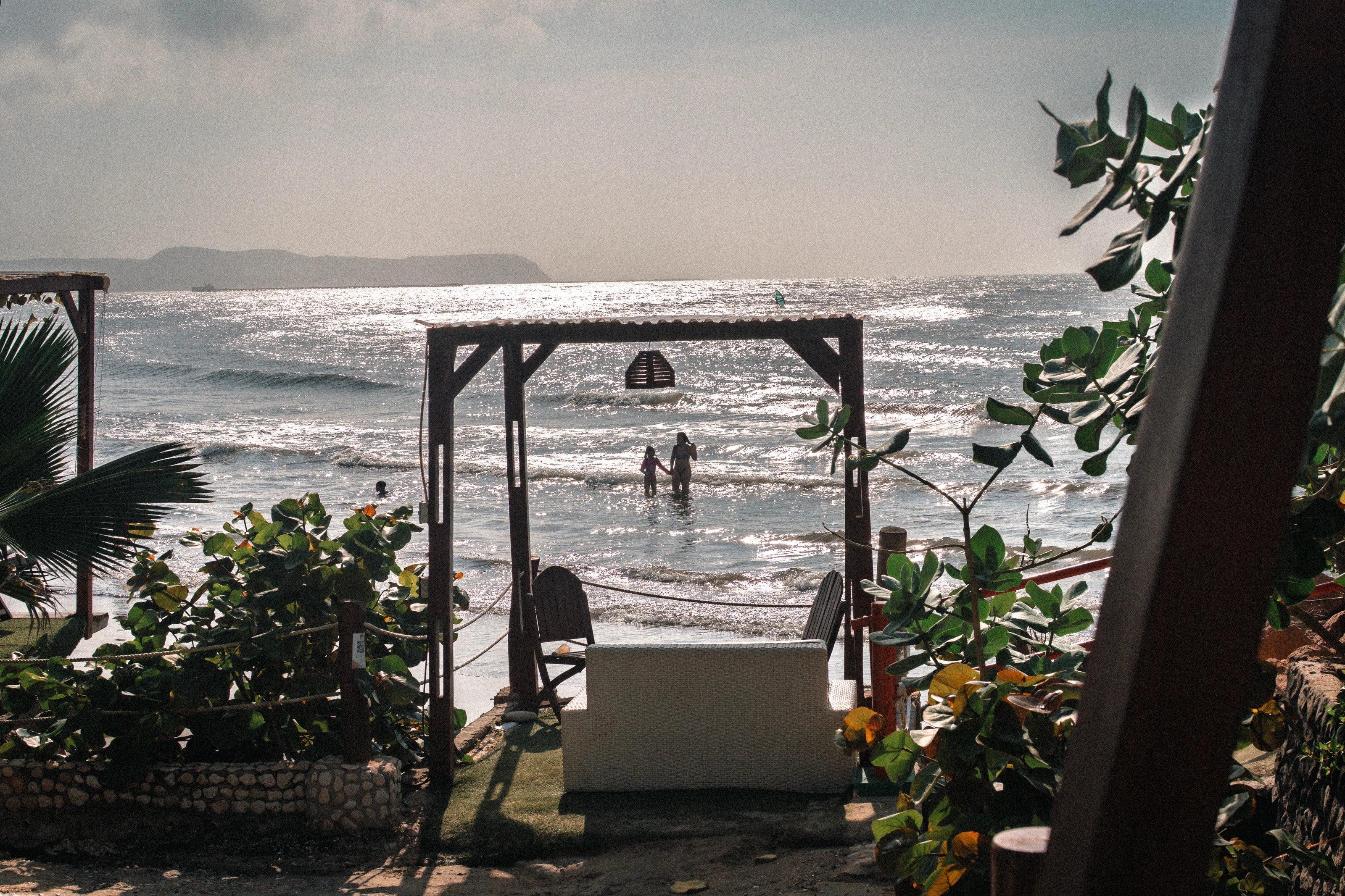 A wooden frame and palms beside the beach