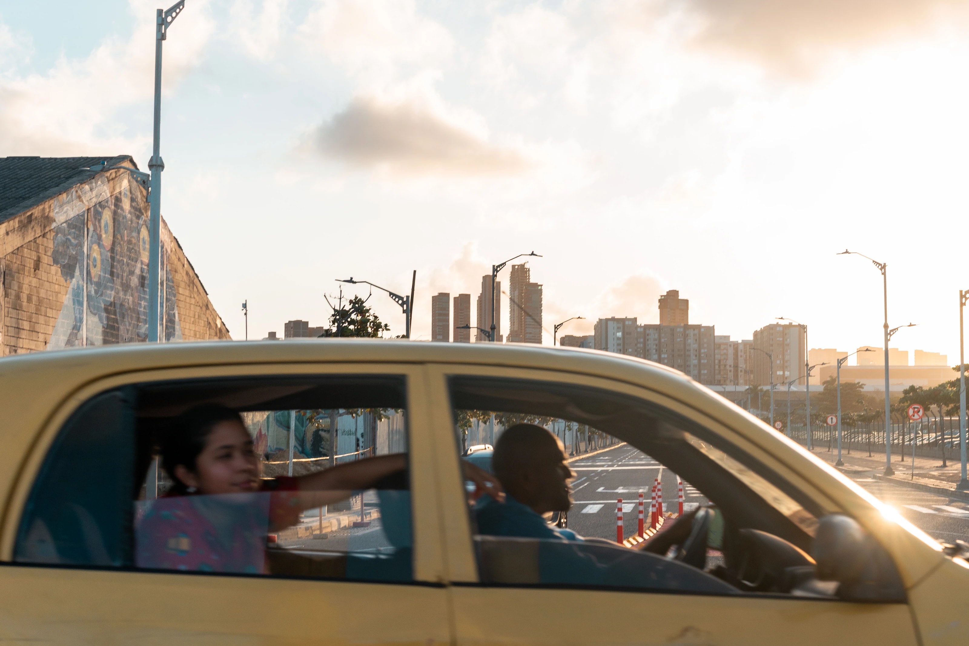 A yellow car crossing an urban street